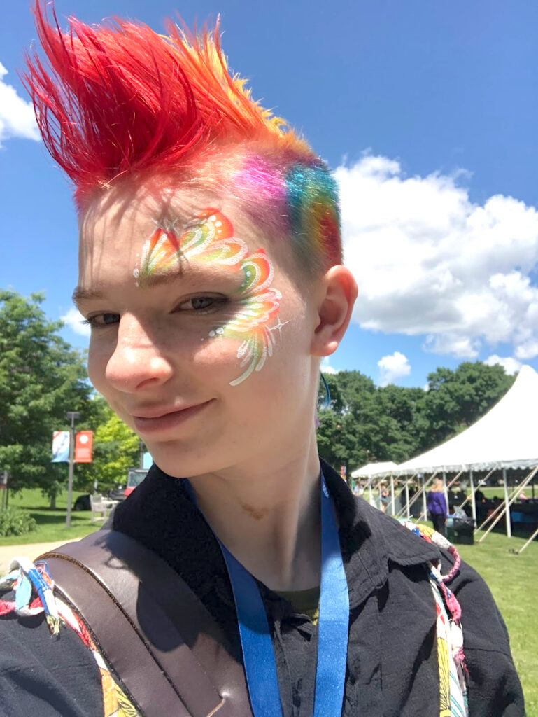 Sylvester Huyck smiles in the sunshine with spiked, colorful hair.